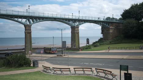 footage-of-Spa-Bridge-in-South-Bay,-Scarborough,-North-Yorkshire-on-a-summer-day-with-people-walking-over-the-bridge