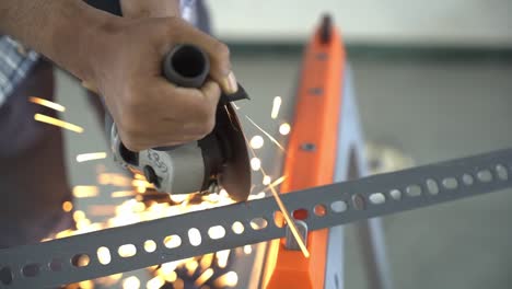 Closeup-of-hands-of-a-South-Asian-man-working-with-an-angle-grinder-generates-fire-sparks