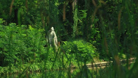 Statue-Eines-Fischers,-Teilweise-Verborgen-Durch-üppiges-Grün