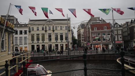 Amsterdam-City-Canal-With-Tourists-In-The-Netherlands---Wide-Shot