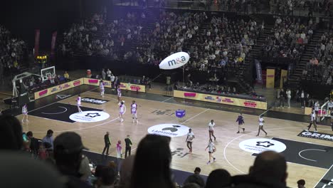 High-angle-slow-motion-shot-of-a-professional-basketball-game-in-an-arena