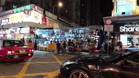 Menschen-Und-Straßenverkehr-Durch-Geschäfte,-Die-Nachts-Im-Stadtteil-Monk-Kok-In-Hongkong-Geöffnet-Sind