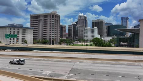 Tráfico-En-El-Cruce-De-Autopistas-Con-El-Moderno-Horizonte-De-Orlando-Durante-El-Día.