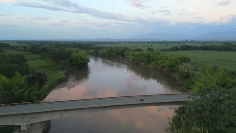 Aerial-View-of-Cauca-River-Near-Bridge-with-Passing-Cars-at-Sunset