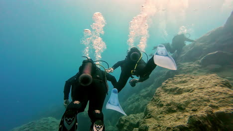 Rear-view-of-snorkeler-with-oxygen-tubes-at-their-back-snorkeling-underneath-sea-in-Greece