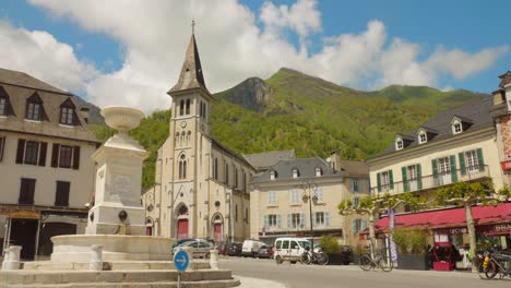 Charmanter-Dorfplatz-In-Laruns-Mit-Einer-Historischen-Kirche-Und-Bergkulisse-In-Den-Pyrenäen