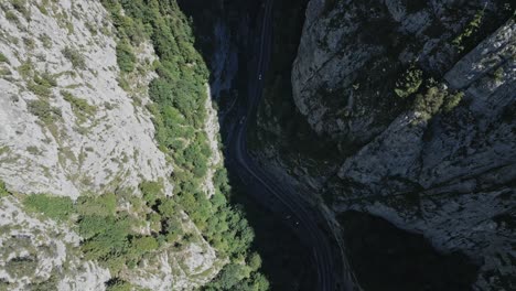 Vista-Aérea-Del-Desfiladero-De-Bicaz-chei-Descendiendo-Gradualmente-Para-Revelar-Dos-Automóviles-Conduciendo-Por-La-Sinuosa-Carretera.