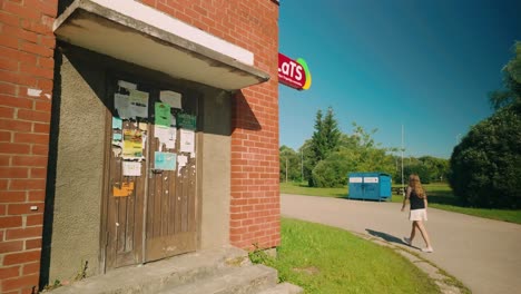 Girl-walks-towards-the-Lats-veikals-shop-in-Latvian-village