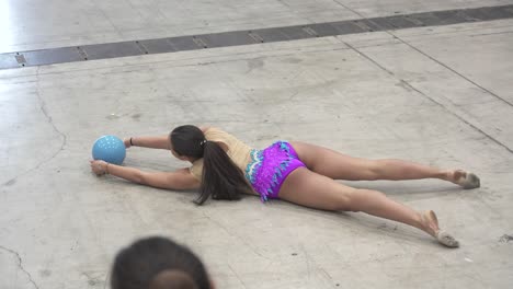 Slow-motion-shot-of-a-gymnast-performing-a-routine-with-a-ball-on-the-floor