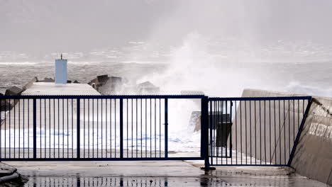 Hermanus-New-Harbour-pier-breakwater-with-dolosse-slammed-with-sea-waves,-slomo