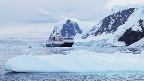 Antarctica-Boat-Trip-with-Mountains-and-Icebergs-in-Antarctic-Peninsula,-Tourists-and-People-Travel-in-Antarctica,-Travelling-in-Beautiful-Dramatic-Scenery-on-Zodiac-Boat-Unique-Adventure-Experience