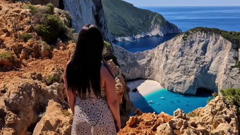 Una-Joven-Turista-Caucásica-Disfruta-De-Las-Vistas-A-La-Famosa-Playa-Del-Naufragio-Navagio.