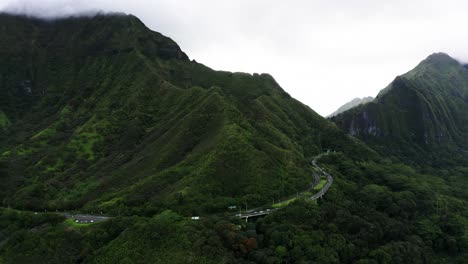 Drone-shot-of-cars-driving-through-Hawaii's-remote-inland-mountains-on-Oahu