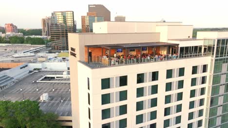 Drone-shot-of-Tourists-sitting-at-Hyatt-Centric-4-star-hotel-rooftop-restaurant-and-bar-in-Buckhead