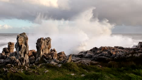 Slow-motion-shot-of-wave-crashing-into-jagged-rocky-coastline-in-Hermanus