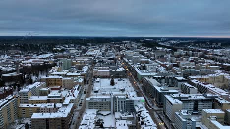 Aerial-tracking-shot-of-downtown-Lahti-city,-gloomy,-winter-evening,-in-Finland