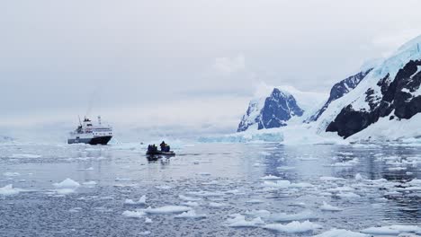 Antarctica-Boat-Trip-and-Scenery-of-Mountains-and-Ice-on-Antarctic-Peninsula,-Tourists-People-Travelling-in-Beautiful-Dramatic-Winter-Scenery-on-Zodiac-Boat-Tour,-a-Unique-Adventure-Travel-Experience