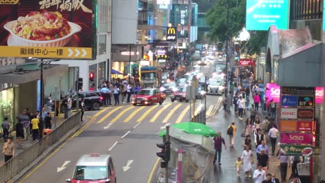 Shops-and-street-traffic-on-crowded-Queen’s-Road-in-Hong-Kong,-overview