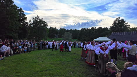 Toma-En-Cámara-Lenta-De-Bailarines-Folclóricos-Estonios-Con-Trajes-Tradicionales-Coloridos-En-El-Museo-Al-Aire-Libre-De-Estonia-Durante-La-Noche