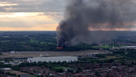 Penacho-De-Humo-Oscuro-Procedente-De-La-Quema-De-Un-Edificio-Abandonado-Al-Atardecer-En-Cheshunt,-Hertfordshire,-Reino-Unido