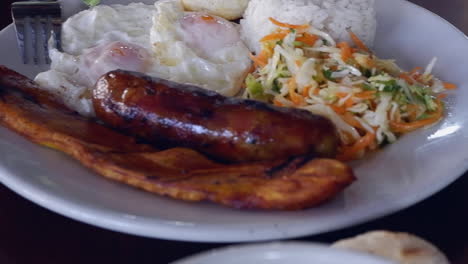 Hearty,-delicious-Bandeja-Paisa-breakfast-on-plate,-Colombia-closeup