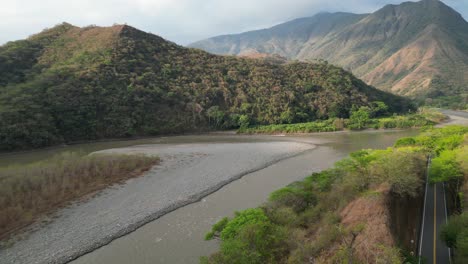 Aerial:-Shaded-highway-follows-Pedral-River-in-lower-Andes-of-Colombia