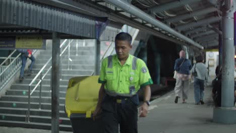 A-worker-in-a-bright-green-uniform-walks-through-Kampung-Bandan-Electric-Train-Station