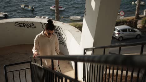 Female-Traveler-Walking-Up-On-Stairs-In-Seafront-Building-On-St