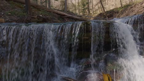 Cascading-waterfall-in-a-serene-forest-with-sunlight-filtering-through-the-trees