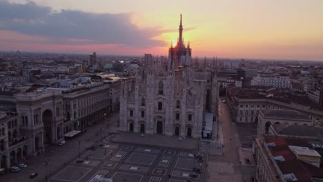 Drone-aerial-orbit-with-frontal-perspective-of-the-Milan-Cathedral-in-the-region-of-Lombardia-Italy-filmed-during-sunrise-and-with-the-sun-peeking-behind-the-building