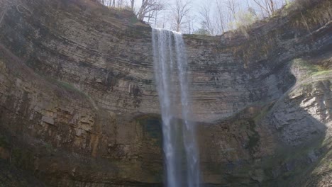 Majestätischer-Wasserfall-Stürzt-Eine-Klippe-Hinab,-Umgeben-Von-Zerklüftetem-Gelände-Und-üppiger-Vegetation