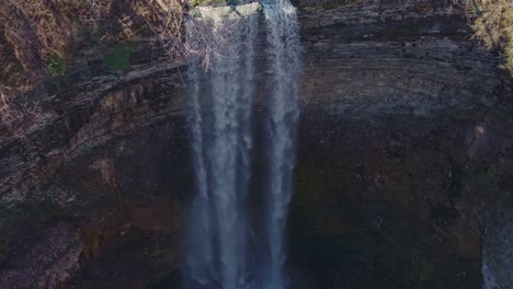 Majestic-waterfall-cascading-down-a-rugged-cliff-surrounded-by-nature