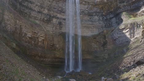 Ein-Hoher-Wasserfall,-Der-Von-Einer-Felsigen-Klippe-In-Einen-Ruhigen-Pool-Darunter-Stürzt,-Umgeben-Von-Natur