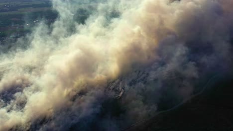 Aerial-drone-view-of-a-huge-smoke-cloud-caused-by-the-Amazon-fires,-pollution,-global-warming,-and-climate-change-in-Brazil,-South-America