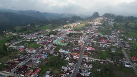 Aerial-orbits-picturesque-Murillo-town-in-Colombian-Andes,-low-cloud