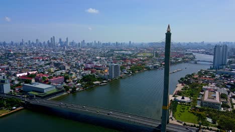 Bangkok,-Tailandia,-Sudeste-Asiático---Una-Vista-Panorámica-Del-Puente-Rama-Viii-Que-Cruza-El-Río-Chao-Phraya,-Con-El-Paisaje-Urbano-Al-Fondo---Toma-Amplia