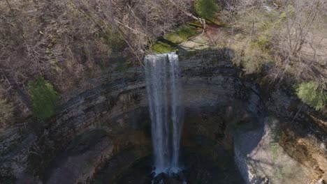 A-stunning-waterfall-cascades-into-a-rocky-basin-in-a-forest-setting