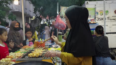 Eine-Frau-Bereitet-Streetfood-Auf-Einem-Geschäftigen-Nachtmarkt-In-Indonesien-Zu