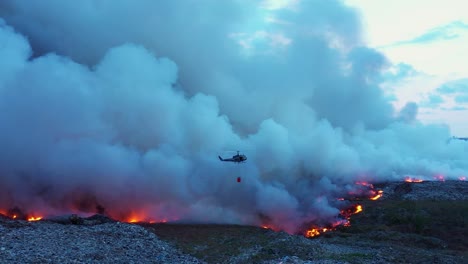 Feuerwehrhubschrauber-Wirft-Wasser-Auf-Buschfeuer,-Dunkle-Abenddämmerung-In-Australien---Panorama-Drohnenaufnahme-Aus-Der-Luft