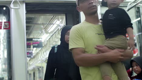 Hombre-Sujetando-A-Un-Niño-En-Un-Tren-En-La-Estación-De-Kampung-Bandan-En-Indonesia