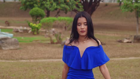 En-Un-Parque-Soleado-En-La-Isla-De-Trinidad-En-El-Caribe,-Una-Chica-Con-Un-Vestido-Azul-Disfruta-Del-Día