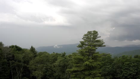 Single-point-panoramic-shot-left-to-right,-capturing-a-cloudy-sky-over-forested-mountainous-area