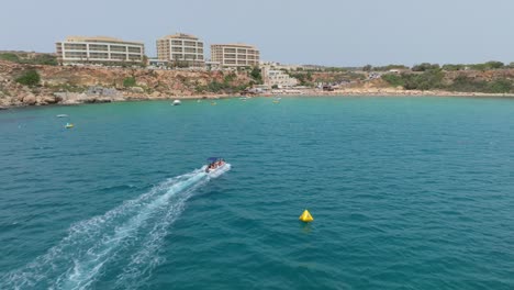 Scenic-Riviera-Beach-With-Tourists-In-Malta---Aerial-Drone-Shot