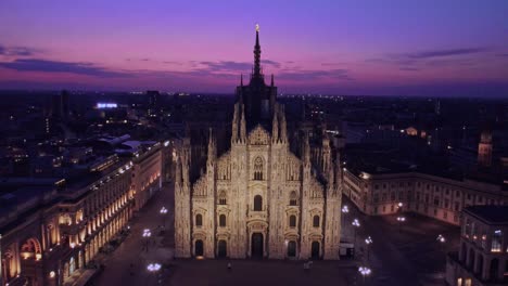 Dolly-out-drone-shot-of-the-duomo-in-Milan,-Italy-during-sunrise-and-blue-hour