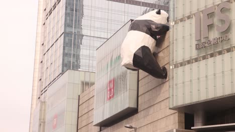 Una-Gran-Escultura-De-Un-Panda-Parece-Trepar-Por-El-Costado-Del-Edificio-Chengdu-Ifs-En-China,-Creando-Una-Exhibición-De-Arte-Urbano-única.