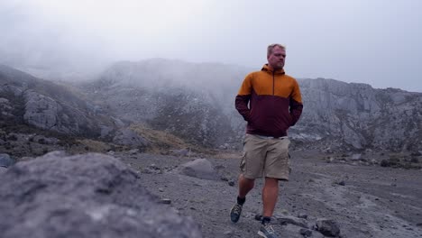 Man-provides-only-color-in-a-grey-mountain-alpine-scene-in-cloud