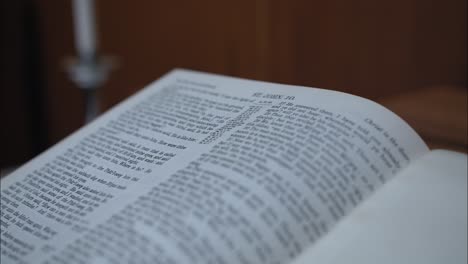 Closeup-of-a-Christian-bible-with-pages-open-to-gospel-of-John-in-old-church-building