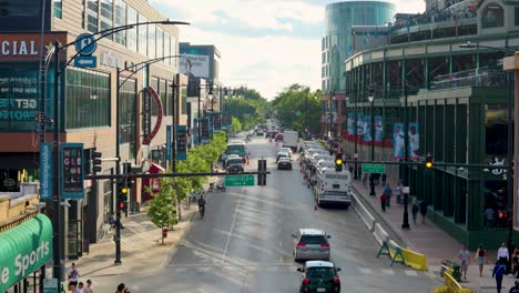 A-bustling-city-street-of-Chicago-with-dynamic-urban-life,-featuring-vehicles,-pedestrians,-storefronts,-and-modern-buildings-under-a-clear-blue-sky