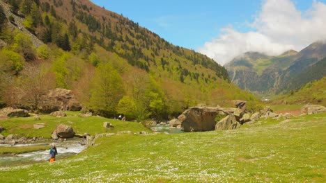 Ein-Grünes-Tal-In-Den-Pyrenäen,-Wo-Die-Menschen-Das-Kühle-Wasser-Eines-Gebirgsbaches-Genießen