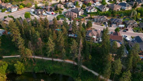 Drone-flying-slowly-in-a-circle-above-a-quiet-neighborhood-overlooking-a-pathway-and-creek